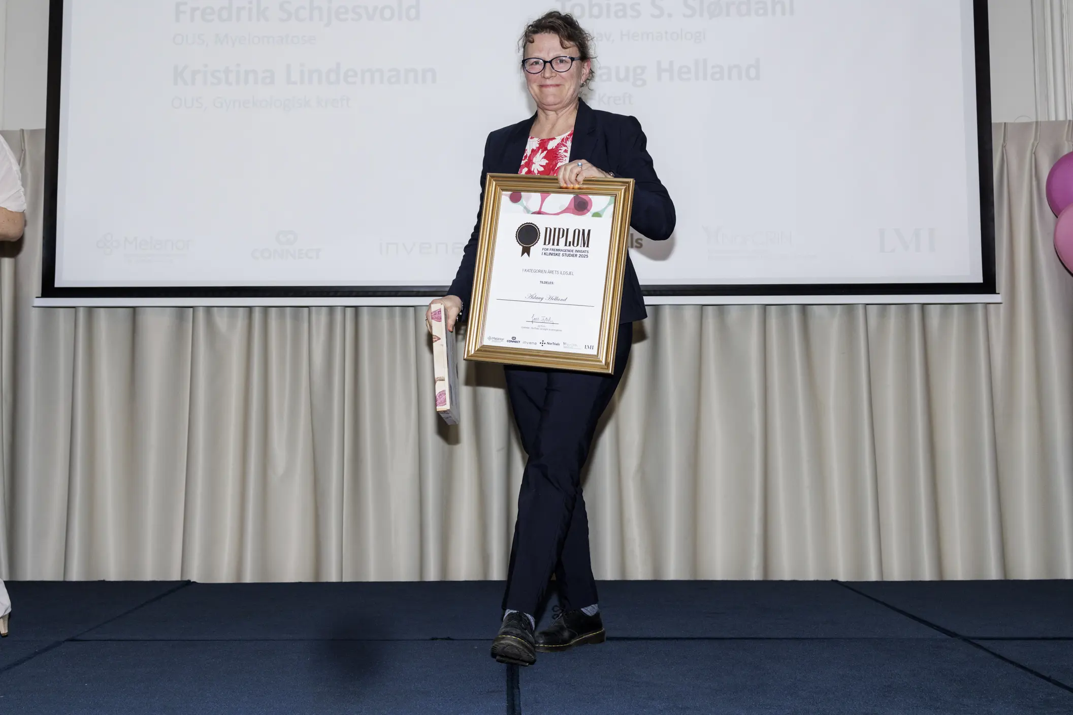 Åslaug Helland med diplom