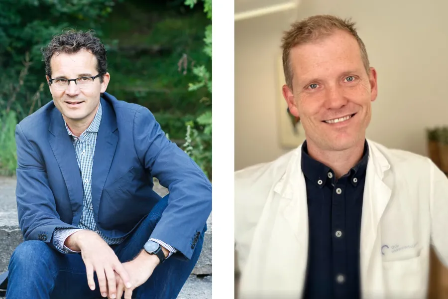 En mann som sitter ved siden av en annen mann og smiler