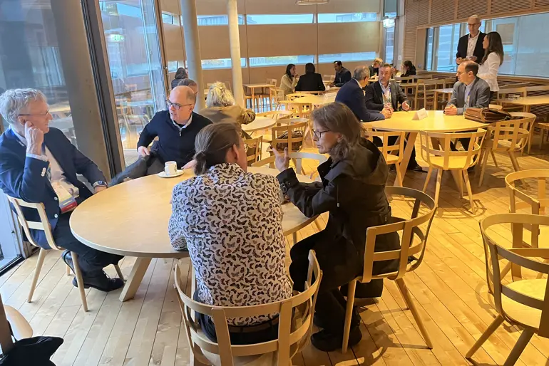 En gruppe mennesker som sitter ved bord