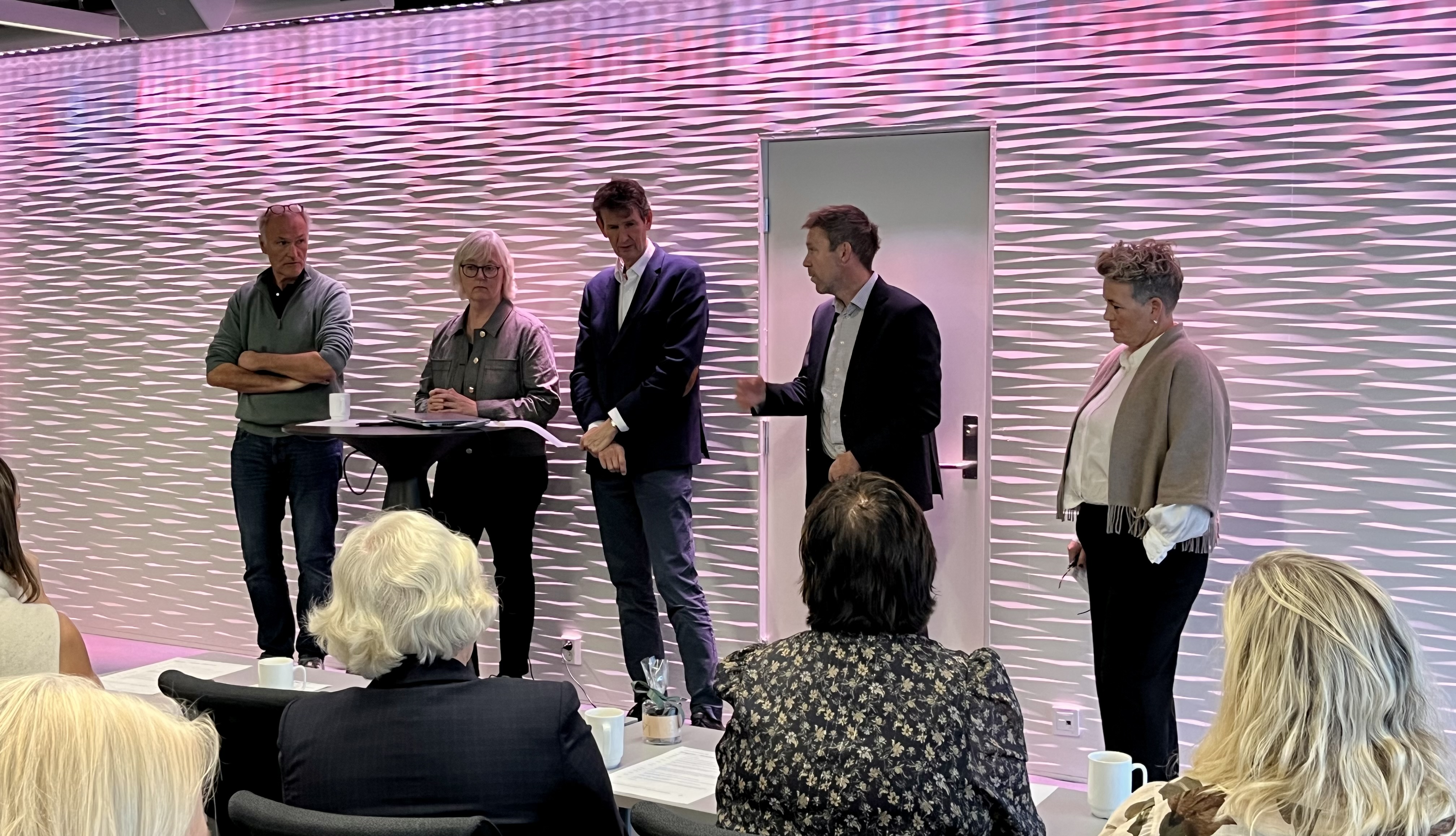 En gruppe mennesker som står foran en skjerm