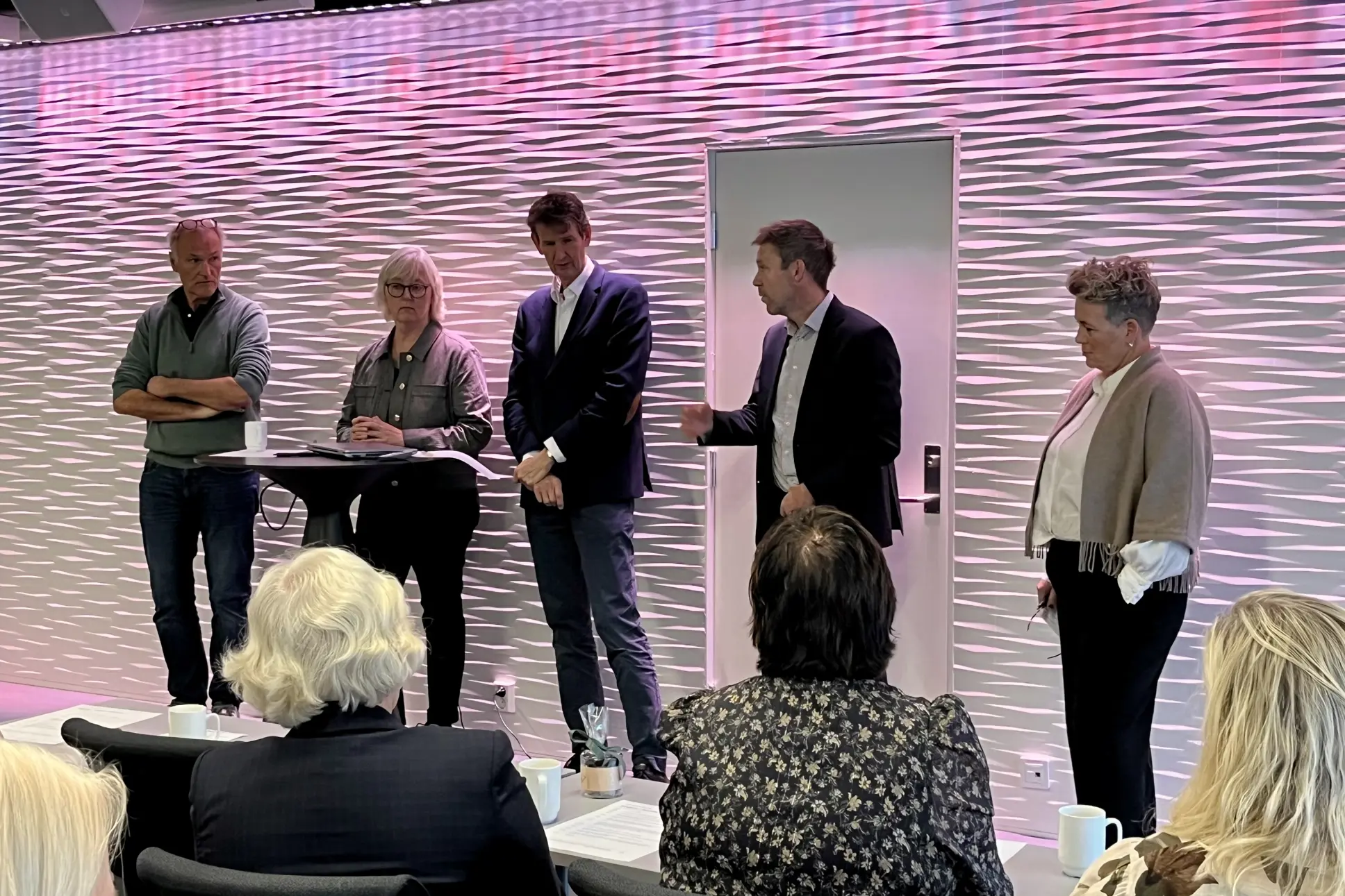 A group of people standing in front of a screen